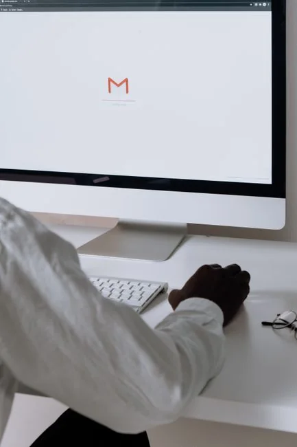 A woman reviewing a brand strategy document on a clipboard beside a laptop in an office setting.